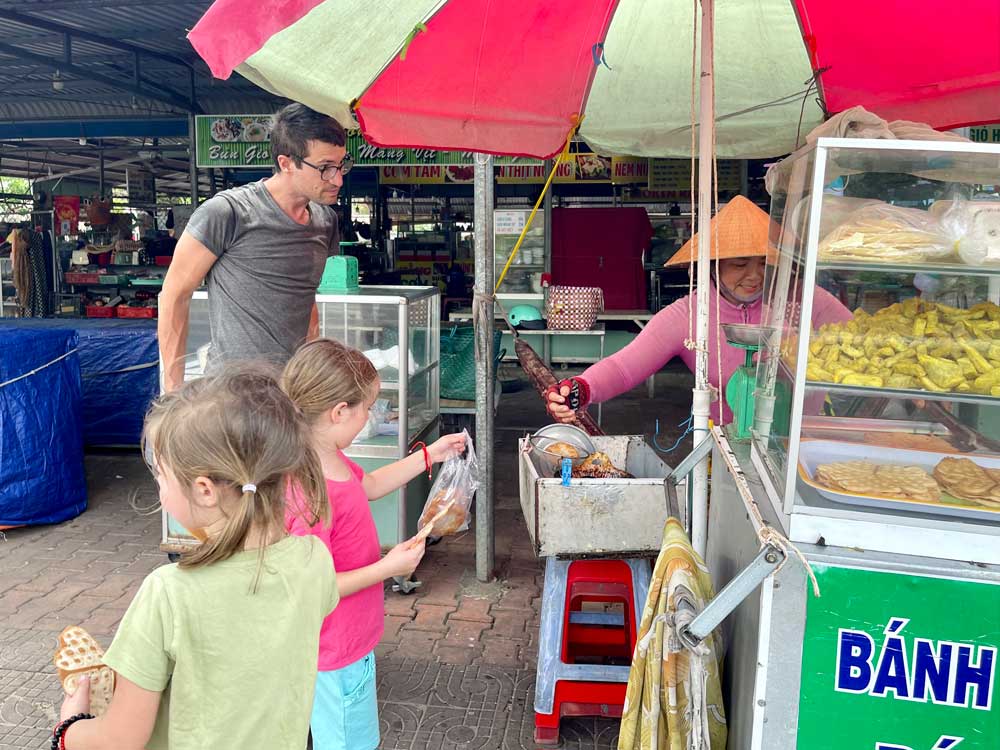 Kinderfreundliche Vietnamesen überall - hier am Straßenstand mit Snacks